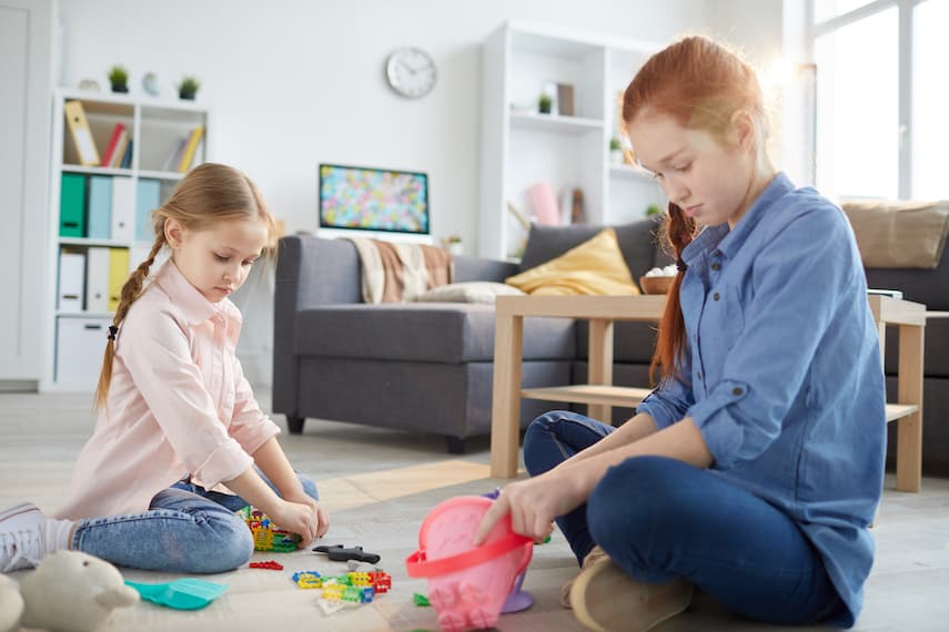 redheaded teenager playing with younger girl in living room