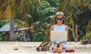 woman working freelance jobs on a laptop while on vacation
