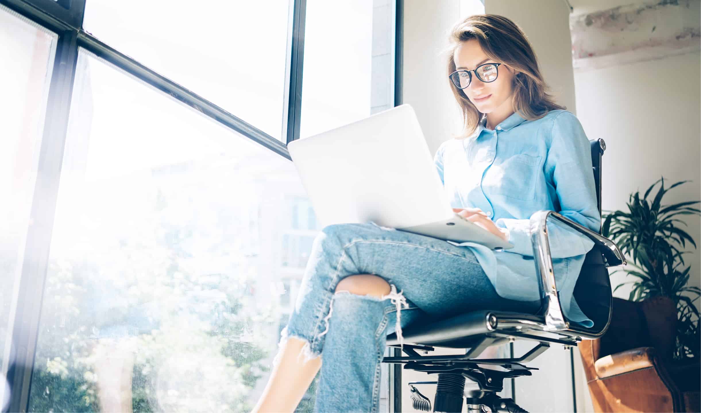woman wearing glasses working on her laptop