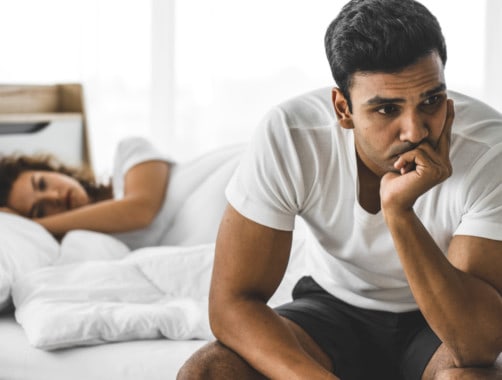 couple in bed, looking away from eachother