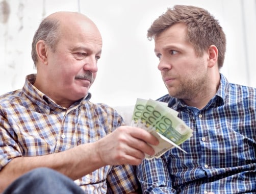 elderly man lending money to his adult son