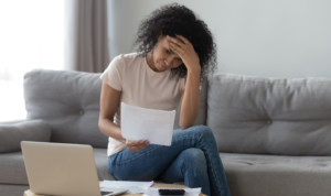 woman with hand on forehead looking at medical bills