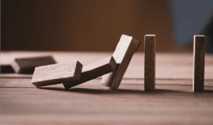 Jenga pieces falling like dominos as an illustration of risk