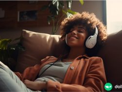 A woman jamming out on her couch with her headphones on