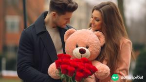 A boyfriend handing his girlfriend a stuffed bear and roses for Valentines day.