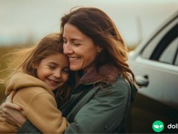 woman hugging child in front of recently received free car