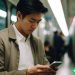 A man on his way to work on the train, watching some video ads on his phone.