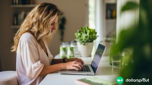 A woman intently focused on her laptop as she types out her thoughts.