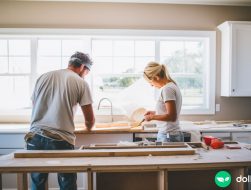 A husband and a wife working together on a kitchen renovation project.