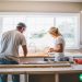 A husband and a wife working together on a kitchen renovation project.