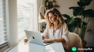 A woman sitting a desk next to a window looking at Facebook on her laptop.