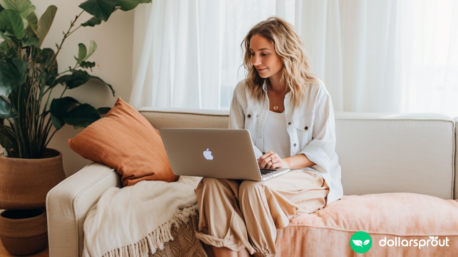 A woman blogging on her laptop while she is sitting on her couch in her living room.