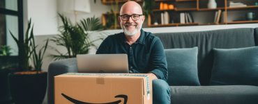A man in his early 50s sitting with his laptop and an Amazon package.