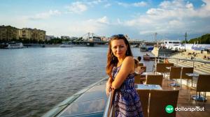 Yulia standing at a railing overlooking a river.