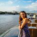 Yulia standing at a railing overlooking a river.