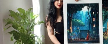 A photo of Laura El posing with one of her prints.