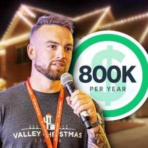 Steve Hunsaker, founder of a seasonal light-hanging side hustle, speaks into a microphone while wearing a Valley Christmas Lights t-shirt. A house lit with holiday lights glows in the background.