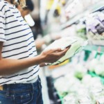 woman looking at her phone in grocery aisle