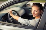 woman holding steering wheel smiling