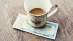 coffee cup setting on 100 dollar bill
