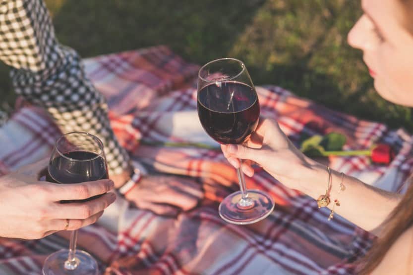 couple drinking wine while having a picnic