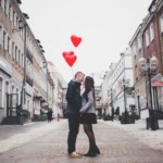 couple standing in street with heart balloons